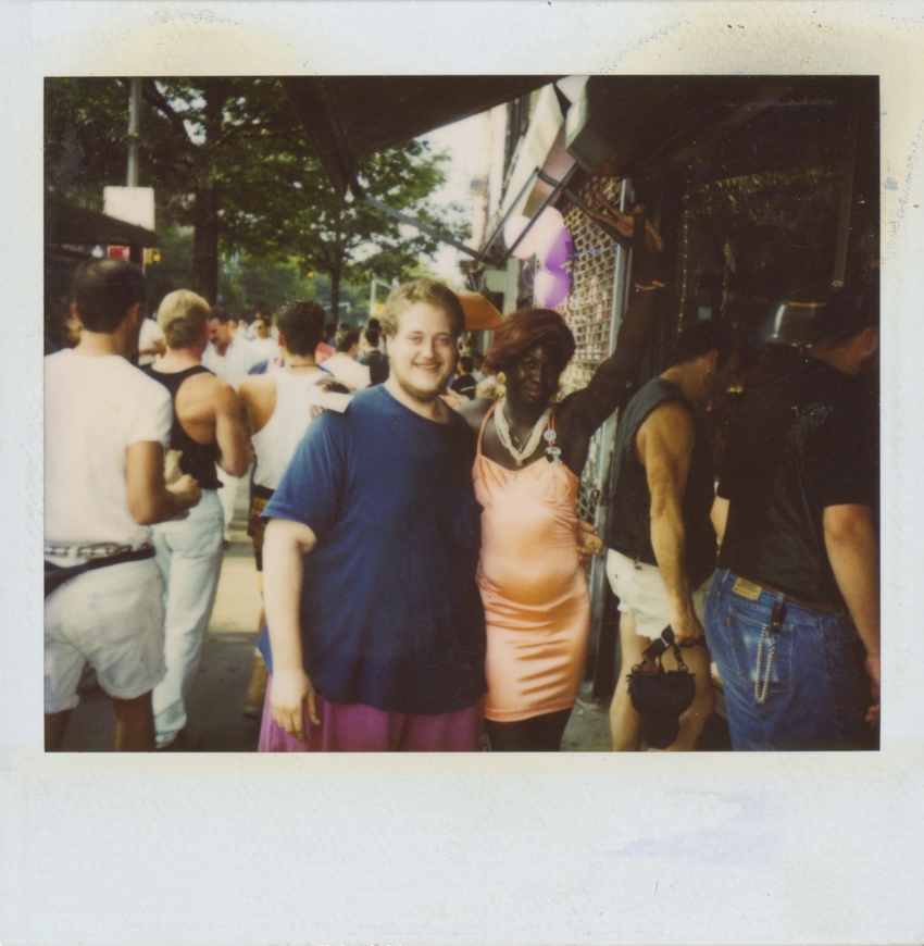 Download the full-sized image of A Photograph of Cocoa Rodriguez in a Peach Dress Posing with Another Person