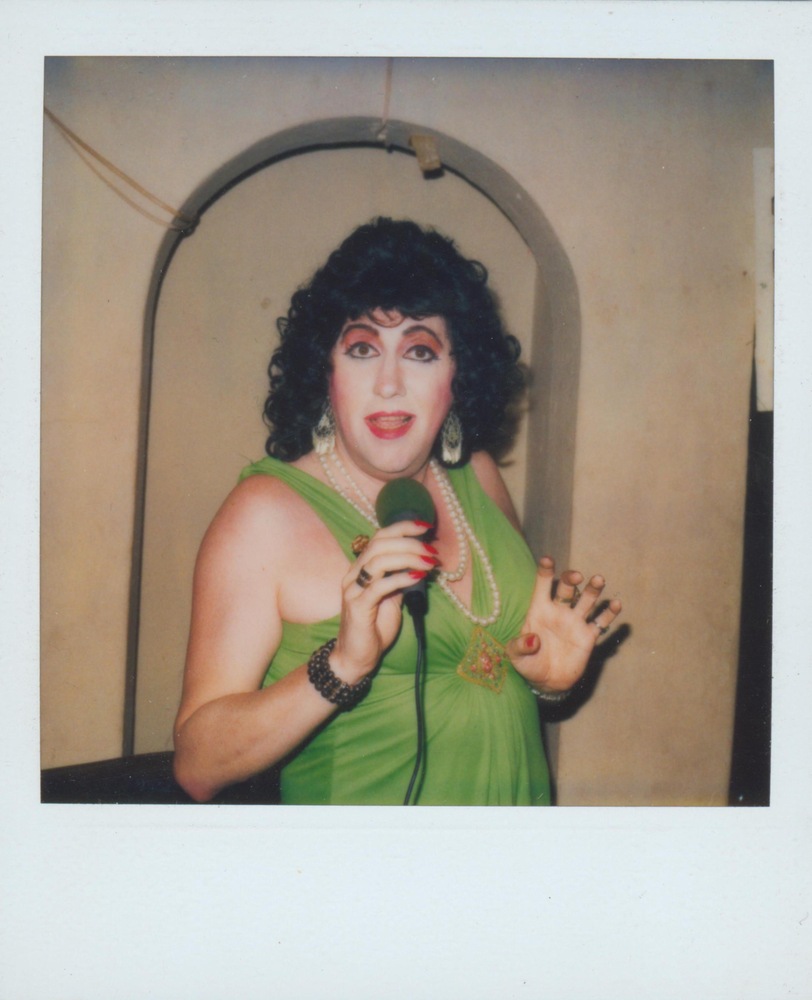 Download the full-sized image of A Photograph of Billie Loba Singing Wearing a Green Dress