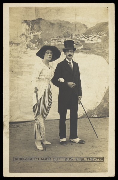 Download the full-sized image of British prisoners of war performing a show at a prisoner of war camp in Cottbus, with Dover cliffs backdrop. Photographic postcard, 191-.