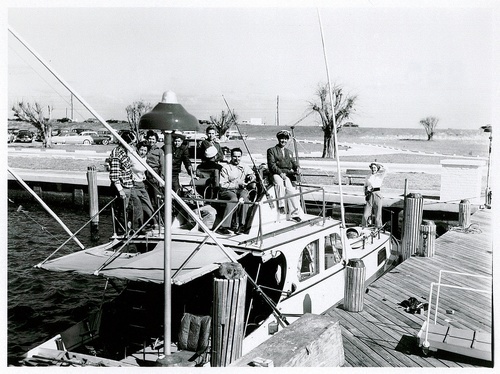 Download the full-sized image of Christine Jorgensen Poses on the Bow of a Boat While Eight Others Gather on Top