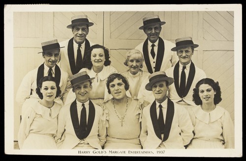 Download the full-sized image of Members of "Harry Gold's Margate Entertainers", one in drag, pose for a group portrait. Photographic postcard, 1937.